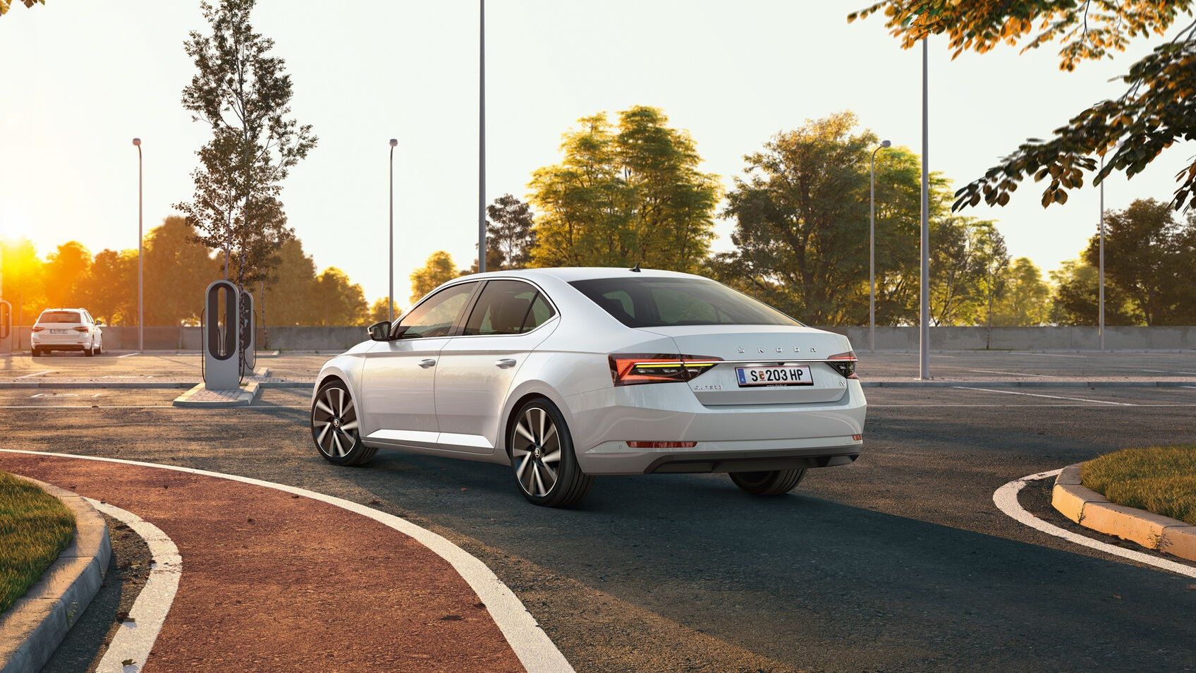 Hinteransicht eines weißen Skoda Auto auf einem Parkplatz mit Ladestation für Elektroautos.